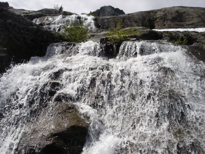 Photo of a waterfall with crystal clear water on dark rocks